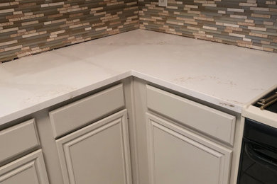 Enclosed kitchen - mid-sized modern l-shaped enclosed kitchen idea in Dallas with granite countertops, beige backsplash, granite backsplash and an island