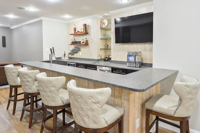 Inspiration for a large modern underground basement remodel in Philadelphia with a bar