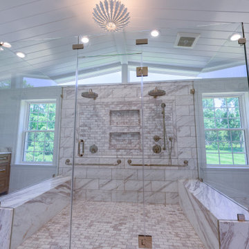 Primary Bathroom with Double Shower and Natural Stone Baseboards
