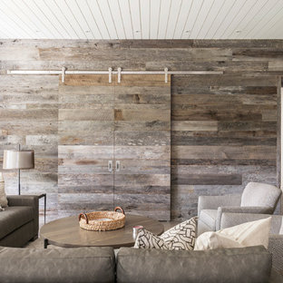 Example of a large farmhouse open concept concrete floor and gray floor home theater design in Other with white walls and a media wall