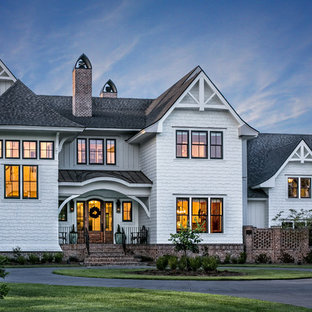 На фото: класса люкс двухэтажные, большие фасады частных домов белого цвета в классическом стиле с облицовкой из дерева и крышей из смешанных материалов