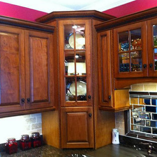 Mid-sized kitchen pantry inspiration - Inspiration for a mid-sized l-shaped kitchen pantry remodel in Huntington with raised-panel cabinets, medium tone wood cabinets, soapstone countertops and stone tile backsplash