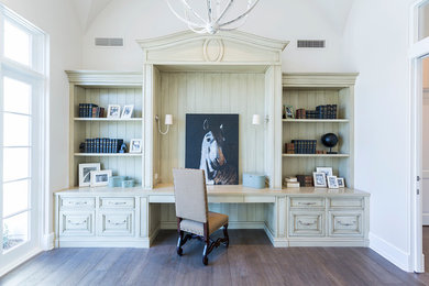 This is an example of an expansive transitional study room in Phoenix with white walls, dark hardwood floors, a built-in desk and brown floor.