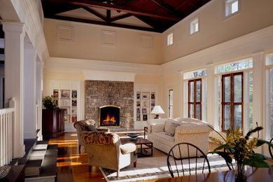 Large elegant enclosed light wood floor family room photo in Other with beige walls, a standard fireplace, a stone fireplace and a corner tv