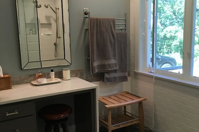 Example of a large transitional master ceramic tile doorless shower design in Milwaukee with flat-panel cabinets, dark wood cabinets, a two-piece toilet, blue walls, an undermount sink and solid surface countertops