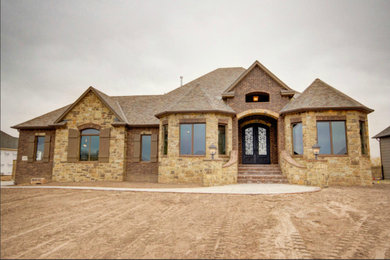 Example of a mid-sized mountain style beige two-story mixed siding gable roof design in Wichita