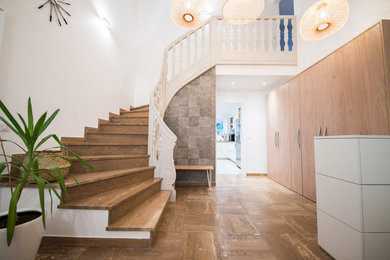 This is an example of a mid-sized contemporary foyer in Strasbourg with white walls, marble floors, a single front door, a white front door and brown floor.