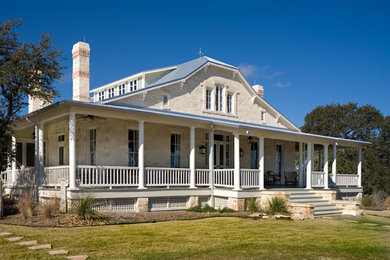 Example of a mid-sized country beige two-story stone exterior home design