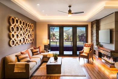 Living room - mid-sized rustic open concept medium tone wood floor and brown floor living room idea in Other with beige walls, a ribbon fireplace, a stone fireplace and a wall-mounted tv