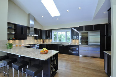 Kitchen - large transitional galley light wood floor kitchen idea in DC Metro with shaker cabinets, black cabinets, granite countertops, beige backsplash, stainless steel appliances and a peninsula