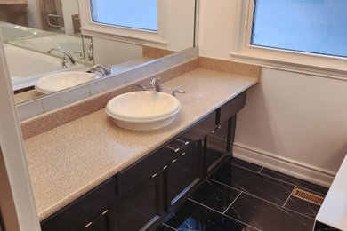 Example of a mid-sized master black tile and cement tile single-sink, cement tile floor and black floor drop-in bathtub design in Toronto with a one-piece toilet, a vessel sink, laminate countertops, brown countertops, a built-in vanity and white walls
