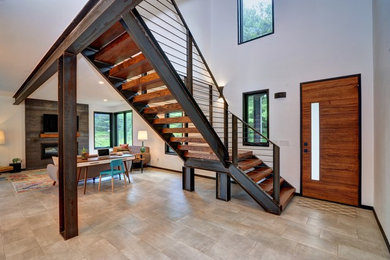 Example of an urban ceramic tile and gray floor entryway design in Other with white walls and a medium wood front door