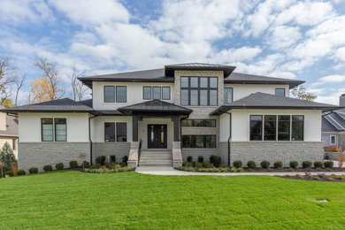 Large minimalist beige two-story mixed siding house exterior photo in Indianapolis with a hip roof and a mixed material roof
