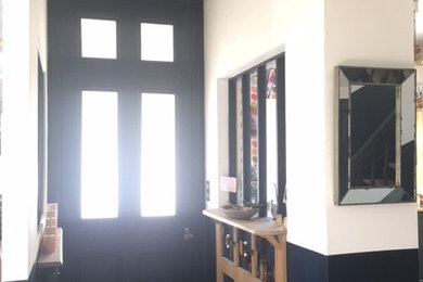 Aménagement d'un petit hall d'entrée rétro avec un mur blanc, une porte simple et une porte bleue.