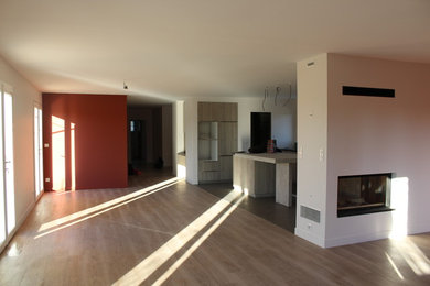 Idées déco pour une grande salle de séjour contemporaine ouverte avec un mur rouge, un sol en vinyl, une cheminée double-face, un manteau de cheminée en plâtre, un téléviseur fixé au mur et un sol gris.