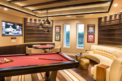 Living room - mid-sized contemporary enclosed medium tone wood floor living room idea in Phoenix with a bar, beige walls, a two-sided fireplace, a stone fireplace and a wall-mounted tv