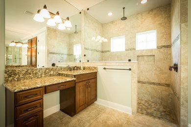 Mid-sized elegant master beige tile and stone tile ceramic tile and beige floor bathroom photo in Jacksonville with raised-panel cabinets, dark wood cabinets, a two-piece toilet, beige walls, an undermount sink and granite countertops