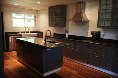 Inspiration for a large country single-wall eat-in kitchen in San Francisco with a farmhouse sink, raised-panel cabinets, granite benchtops, stainless steel appliances, dark hardwood floors, with island and brown floor.