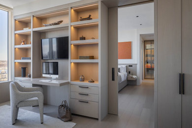 Example of a mid-sized trendy built-in desk light wood floor and beige floor study room design in New York with beige walls