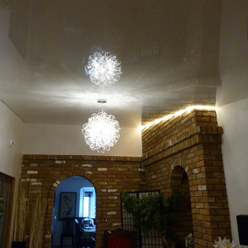 White high gloss Phoenix Stretch Ceiling with LED lighting around the brick wall