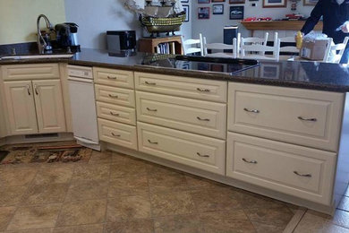 Inspiration for a mid-sized timeless u-shaped porcelain tile and brown floor eat-in kitchen remodel in San Francisco with an undermount sink, raised-panel cabinets, beige cabinets, quartz countertops, green backsplash, stone slab backsplash, stainless steel appliances and a peninsula
