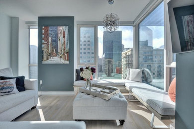 Example of a small trendy open concept light wood floor living room design in San Francisco with no fireplace, a wall-mounted tv and blue walls