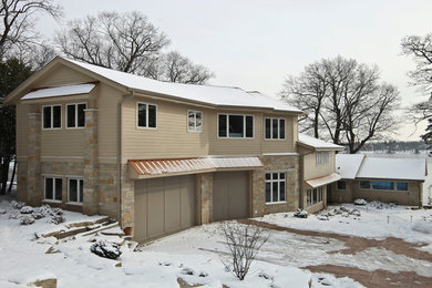 Huge trendy beige two-story stone exterior home photo in Milwaukee