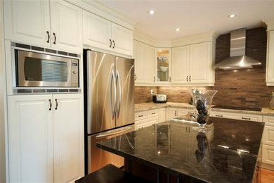 Inspiration for a mid-sized transitional u-shaped light wood floor open concept kitchen remodel in Toronto with a double-bowl sink, raised-panel cabinets, stainless steel cabinets, granite countertops, brown backsplash, stone tile backsplash, stainless steel appliances and an island