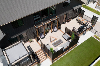 Deck - modern backyard ground level metal railing deck idea in Other with a fire pit and a pergola