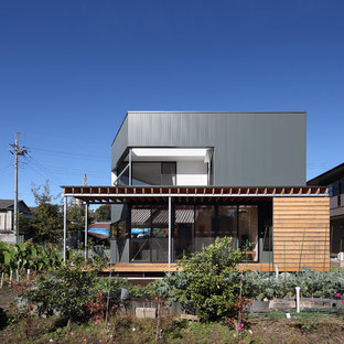 他の地域のコンテンポラリースタイルのおしゃれな二階建ての家 (メタルサイディング、緑の外壁、陸屋根、戸建) の写真