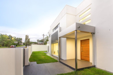 Mid-sized contemporary two-storey white house exterior in Brisbane with a flat roof.
