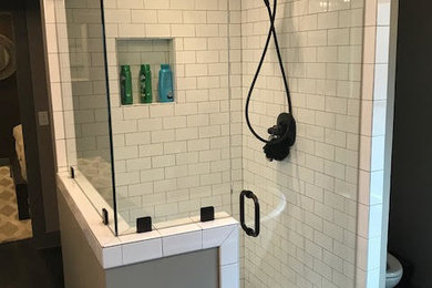 Inspiration for a large transitional 3/4 white tile and subway tile laminate floor and gray floor corner shower remodel in Birmingham with beige walls, a two-piece toilet, a pedestal sink, solid surface countertops, a hinged shower door and white countertops