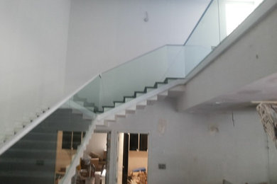Imagen de escalera suspendida moderna de tamaño medio con escalones de vidrio y contrahuellas de metal