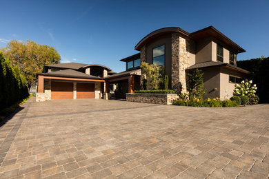 Design ideas for a large contemporary front yard partial sun driveway for summer in Other with concrete pavers.