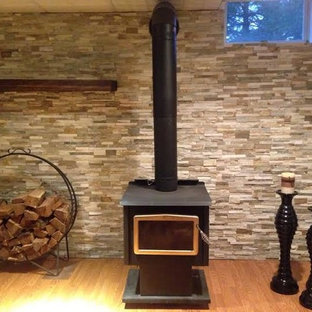 Photo of a large rustic look-out basement in Philadelphia with multi-coloured walls, medium hardwood flooring, a wood burning stove and brown floors.