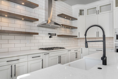 Example of a l-shaped kitchen design in Denver with a farmhouse sink, shaker cabinets, stainless steel appliances and two islands