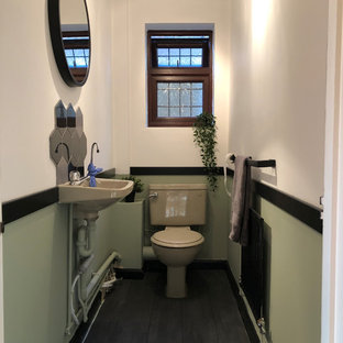 Ispirazione per un piccolo bagno di servizio country con WC monopezzo, pareti multicolore, pavimento in laminato, lavabo sospeso e pavimento grigio