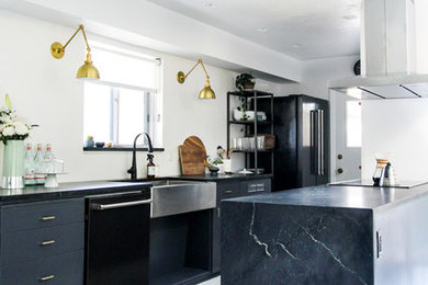 Kitchen - mid-sized scandinavian galley painted wood floor and white floor kitchen idea in Boise with a farmhouse sink, flat-panel cabinets, gray cabinets, soapstone countertops, black appliances and a peninsula