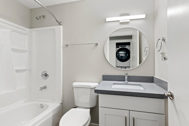 Alcove bathtub - small craftsman vinyl floor, gray floor and single-sink alcove bathtub idea in Seattle with shaker cabinets, white cabinets, a two-piece toilet, gray walls, an undermount sink, quartz countertops, gray countertops and a built-in vanity