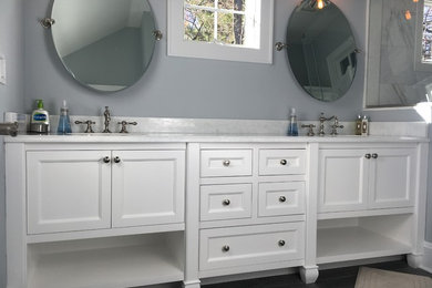 Inspiration for a mid-sized transitional master gray tile and marble tile brown floor and vinyl floor alcove shower remodel in New York with furniture-like cabinets, white cabinets, gray walls, an undermount sink and laminate countertops