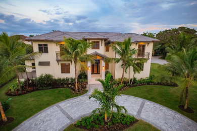 Large brown two-story concrete exterior home idea in Miami