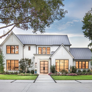 Cottage white two-story brick exterior home photo in Dallas with a metal roof