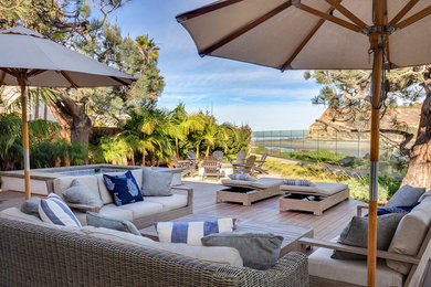 Large beach style backyard patio in San Diego with an outdoor kitchen, decking and no cover.