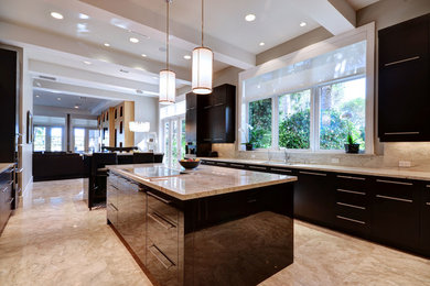 Eat-in kitchen - large contemporary u-shaped marble floor eat-in kitchen idea in Miami with an undermount sink, flat-panel cabinets, black cabinets, granite countertops, beige backsplash, stone slab backsplash, stainless steel appliances and an island