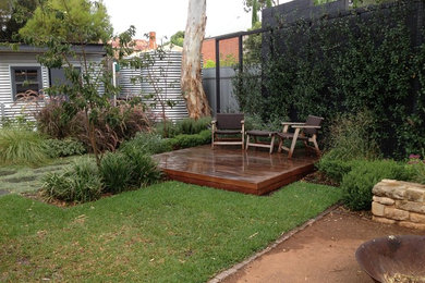 This is an example of a mid-sized contemporary backyard garden for spring in Adelaide with a fire feature and decking.