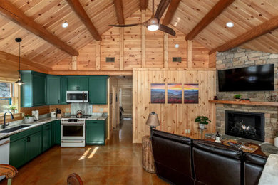 Mid-sized mountain style enclosed concrete floor, multicolored floor, exposed beam and wood wall living room photo in Other with a corner fireplace, a stone fireplace and a wall-mounted tv