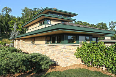 Example of a transitional beige three-story stone house exterior design in Other with a hip roof and a shingle roof