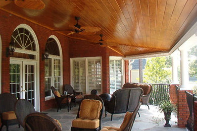 This is an example of a large traditional backyard verandah in Atlanta with an outdoor kitchen, natural stone pavers and a roof extension.