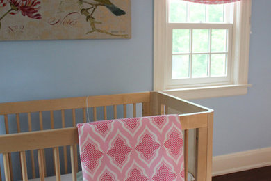 This is an example of an eclectic nursery for girls in New York with blue walls.