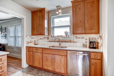 Mid-sized elegant l-shaped ceramic tile eat-in kitchen photo in Denver with an undermount sink, shaker cabinets, light wood cabinets, quartz countertops, beige backsplash, ceramic backsplash, stainless steel appliances and a peninsula